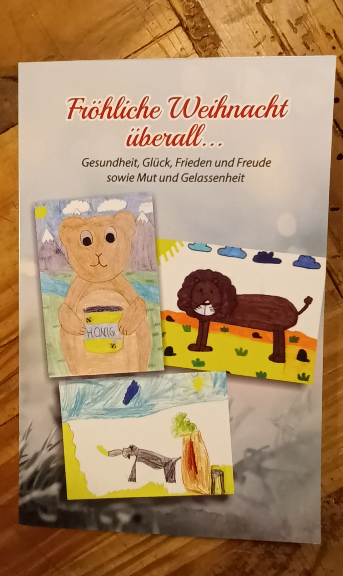 Weihnachtskarte mit drei gemalten Bildern von Kindern die am Wettbewerb teilgenommen haben